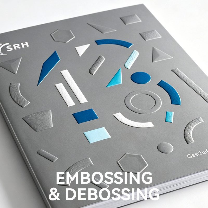 Grey book cover demonstrating both raised embossing and indented debossing techniques on various geometric shapes.