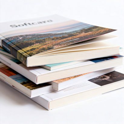 Stacked custom softcover books and perfect bound catalogs showcasing high-quality offset printing and matte lamination.